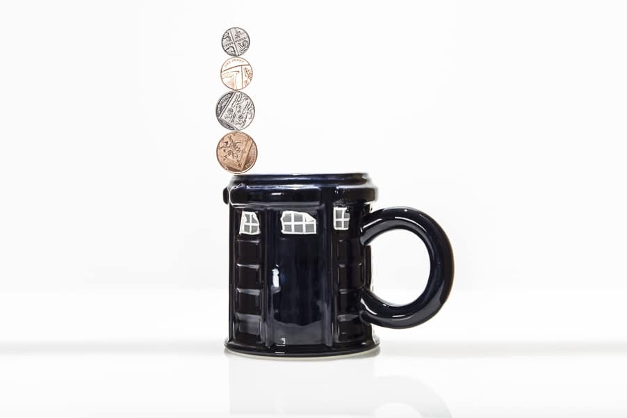 Coins magnetically balanced on the rim of a mug