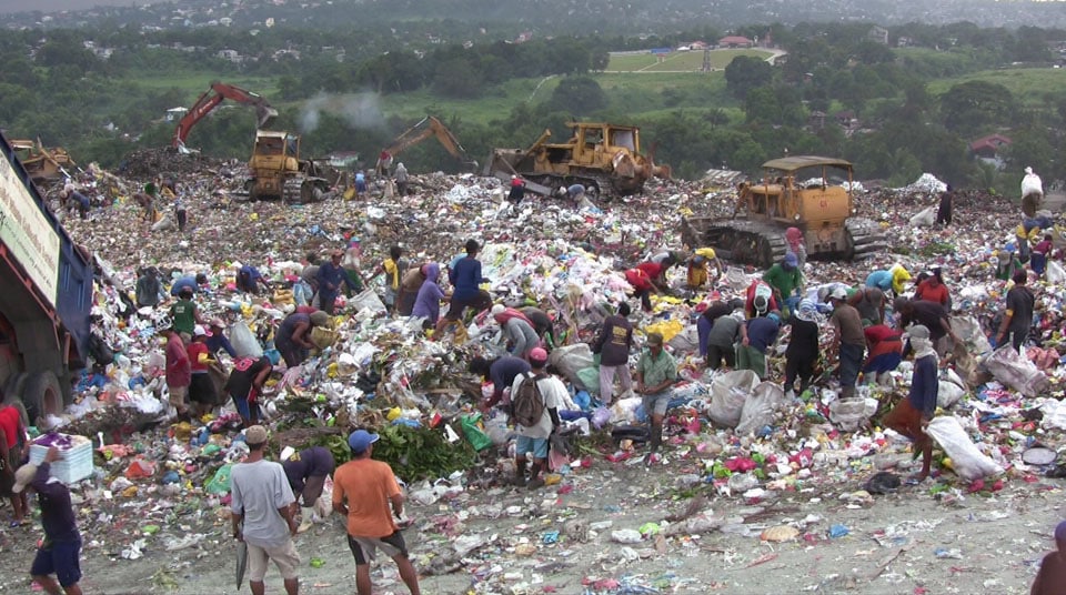 People trawling through rubbish looking for materials to sell in Manila, The Philippines